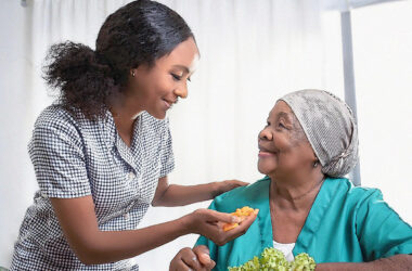 Woman helping an elder enjoy new foods